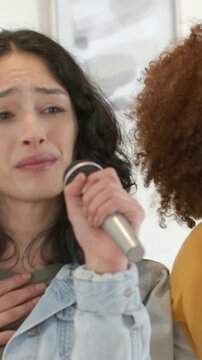 Vertical video: Song starting driving woman in denim jacket singing into mic at home rehearsing