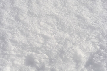 Obraz premium Detailed top view of fresh white snow texture with small crystalline structures reflecting bright winter sunlight