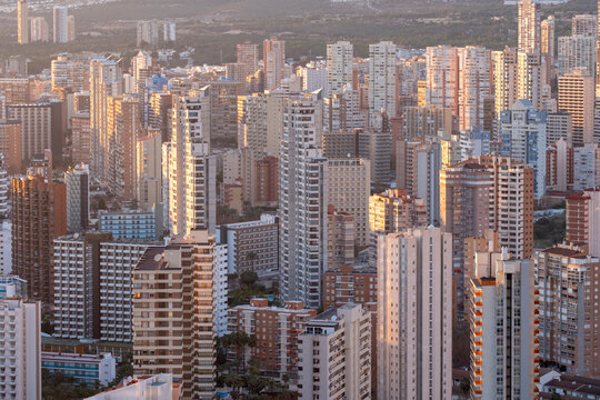 A prominent tower rises within the Benidorm Spain skyline as dense city skyscrapers and urban architecture glow at sunset over the modern city scene