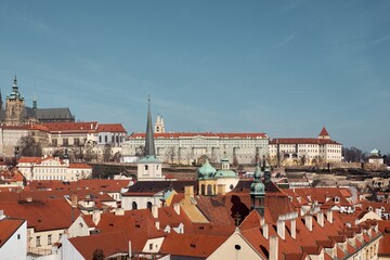 Naklejka premium Prague Castle and St Vitus Cathedral rise above red tiled roofs of Malá Strana