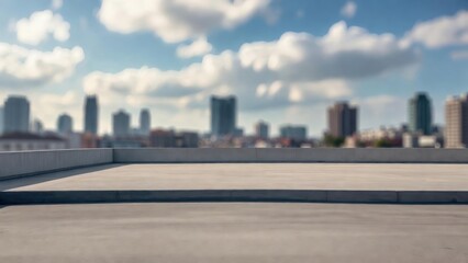 Obraz premium Concrete rooftop overlooks distant city skyline. Blue sky, fluffy clouds frame urban skyline. Smooth surface, low walls frame expansive view. Ideal backdrop for product display or business concept