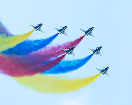 Aerial view of fighter jets soaring through the sky, painting vibrant trails of yellow, red, and blue against a serene backdrop, Changi Exhibition Centre, Singapore Air Show 2026, Singapore.