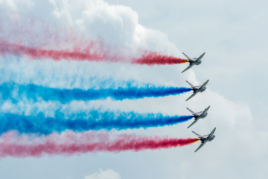 Aerial view of five aircrafts soaring in formation, leaving vibrant trails of red and blue smoke against the expansive sky, Changi Exhibition Centre, Singapore Air Show 2026, Singapore.