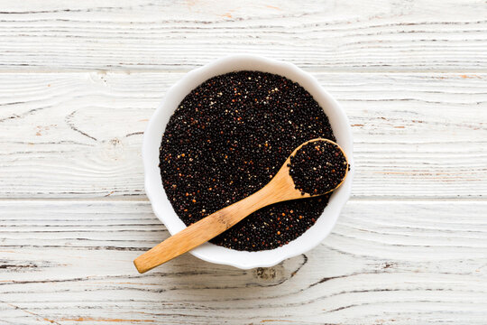 quinoa seeds in bowl and spoon on colored background. Healthy kinwa in small bowl. Healthy superfood