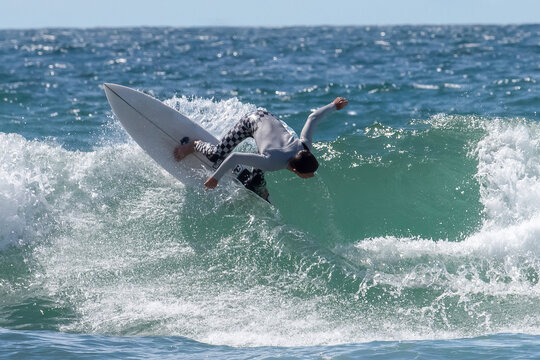A dynamic action shot of a surfer skillfully riding an ocean wave,