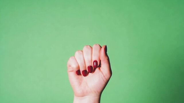 Woman's hand with red nail polish opening from a fist to a flat palm 4k Video. generated with AI