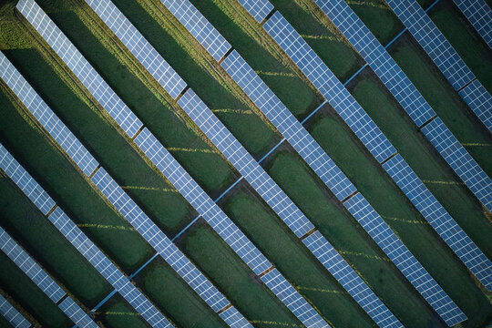 Aerial view of solar panels arranged in parallel lines contrasting with the green fields, a sustainable energy landscape, Stoke-on-Trent, England, United Kingdom.