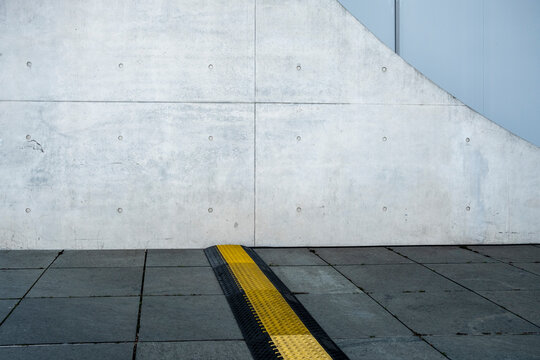 Minimal urban concrete wall and pavement with abstract geometry and a bold line accent forming a clean architectural background with copy space