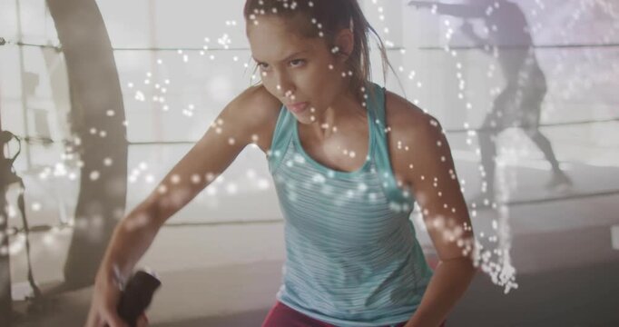 Woman gripping ropes, powering alternating waves for boxing as dotted overlays accenting motion