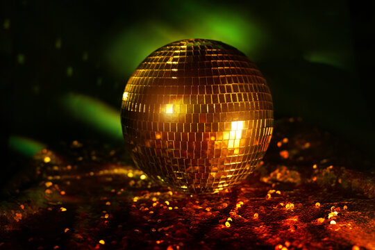 Golden disco ball with reflections in night club setting
