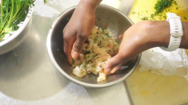 African chef prepares fresh shrimp and herbs for a traditional culinary dish