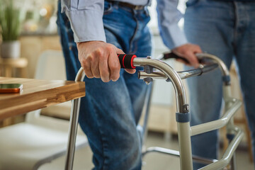 Senior man using walker experiencing mobility challenges at home