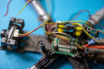 Close-up of a 5-inch FPV drone ESC during repair, with exposed wiring, solder joints, and power...