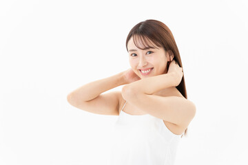 Obraz premium 白背景でヘアケアをする若い女性のビューティーイメージ