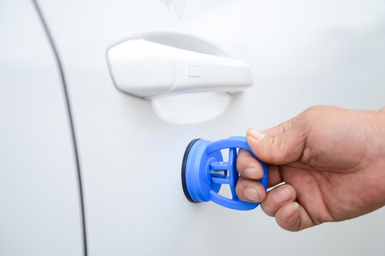 A Hand Holding a Sucker for Car Paintless Dent Repair