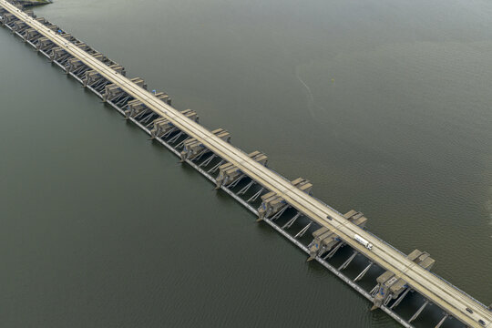 Aerial view of the Haringvlietdam bridge slicing through the dark waters, a modern marvel of engineering, Haringvlietdam, South Holland, Netherlands.