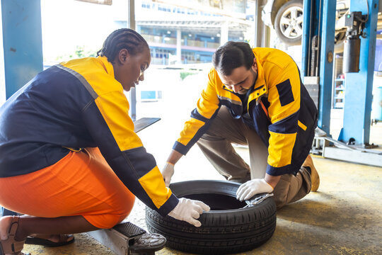 Auto repair shop, small business owner, garage, technology, diversity couple Indian and African woman work together, collaborative teamwork, confident service skills, automobile service workshop.