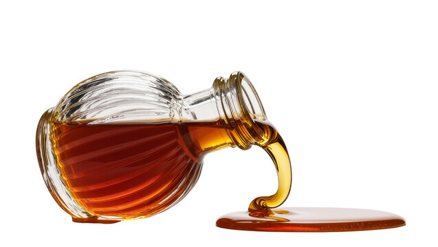 Isolated glass bottle pouring viscous golden amber syrup into a sweet sticky puddle