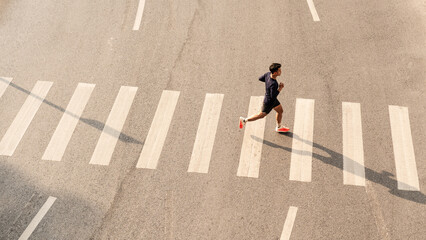 Obraz premium Young man run on pedestrian crosswalk in city street workout training