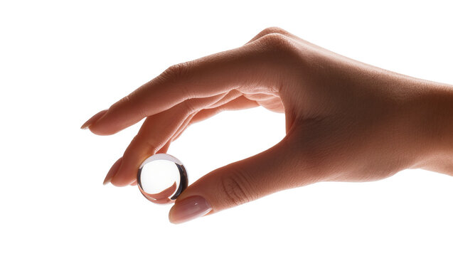 Isolated female hand gently holding a clear transparent glass sphere or crystal ball.