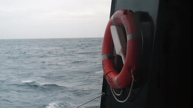 Moody view of the wavy sea under an overcast sky with a ship's lifebuoy in the frame