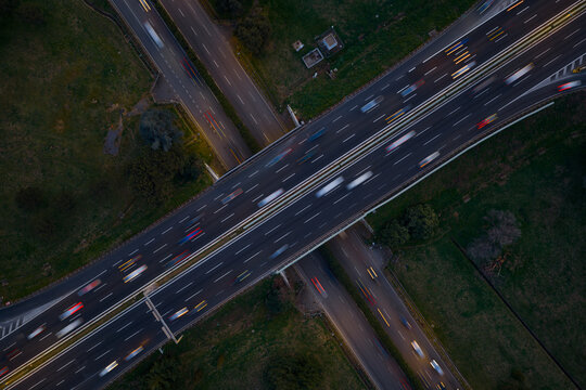 Aerial view of cars speeding along the highway, a concrete ribbon cutting through the verdant landscape, Rome, Lazio, Italy.