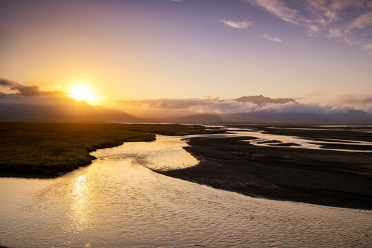 Sunrise over braided glacial rivers and black sand flats in Iceland