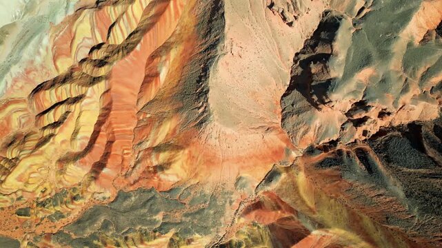 Aerial drone view of layered sandstone cliff formations in Zhangye Danxia Geopark, Gansu Province, China