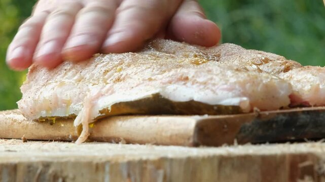 Extreme macro close-up of fresh raw catfish fillet on a wooden board
