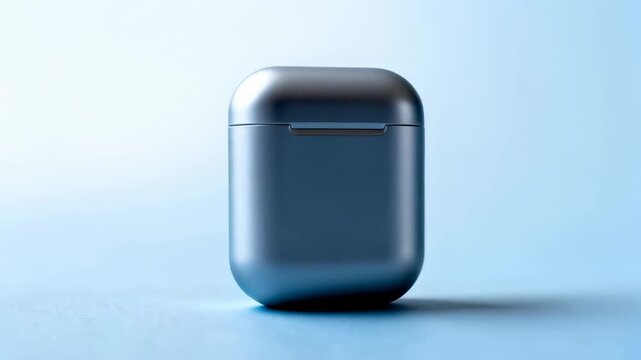 Slow dolly in closeup of wireless earbud case rotating and approaching on blue tabletop studio surface