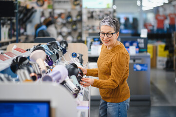 Woman shopping for hair care appliances in electronics store