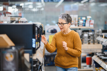 Senior woman choosing electronics in a retail store