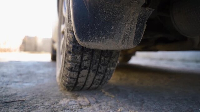 Car starting to move, close-up of rear wheel tire rubber