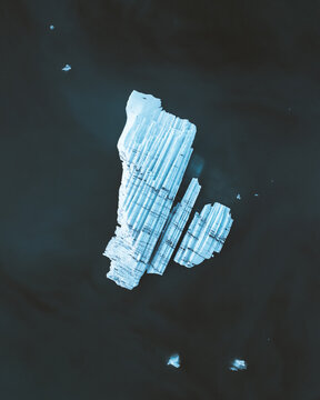 Aerial view of a majestic iceberg, its icy blue hues contrasting against the dark, still waters of Jokulsarlon glacial lagoon, Sveitarfelagid Hornafjordur, Iceland.