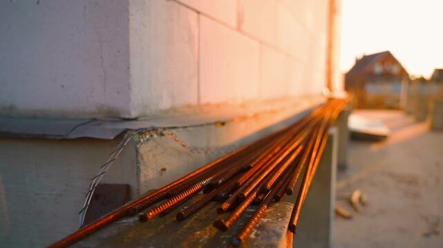 Rusty rebar at construction site at sunrise on blurred background. Smooth camera movement