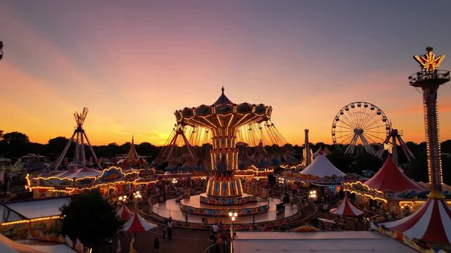 This video presents an elevated view of a classic chair swing carousel in warm sunset light, vibrant theme park scenery, and playful motion design ideal for summer lifestyle storytelling.