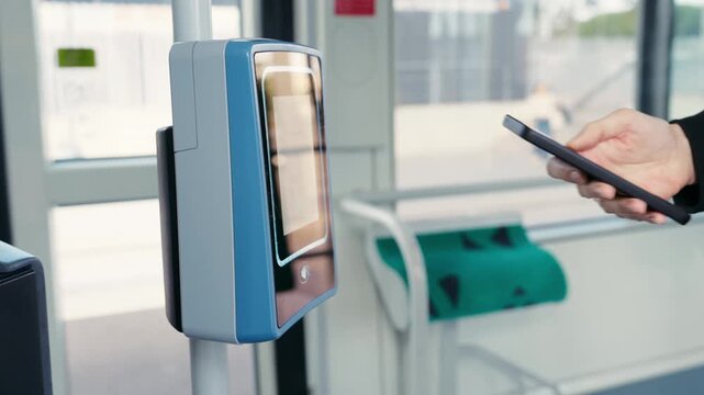 Video of close up of woman paying for the tram ride with her smartphone