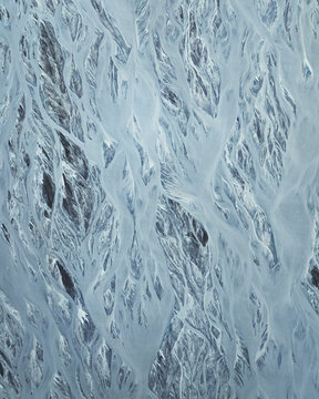 Aerial view of glacial rivers weave through the landscape, creating a mesmerizing pattern of icy blues and dark earth, Skaftarhreppur, Skaftarhreppur, Iceland.