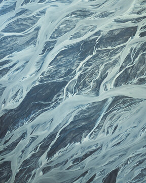 Aerial view of braided glacial rivers carve paths through the stark, contrasting landscape, Skaftarhreppur, Iceland.
