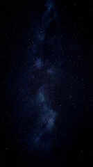 Obraz premium Vertical shot of a vast black starry sky filled with countless small white stars and the Milky Way galaxy. Detailed astronomical background of deep dark space, perfect for cosmic and sci-fi designs.