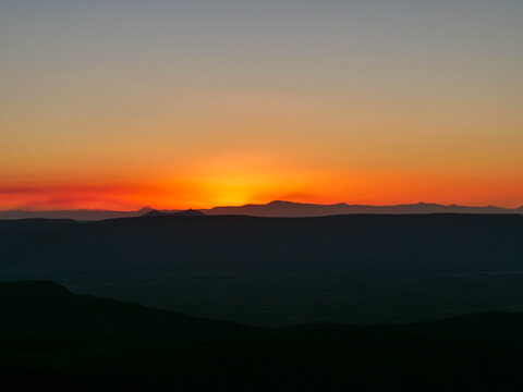 Deep orange and yellow sunset over the mountains in Tankwa Karoo area in South Africa from the top of the Ouberg Pass