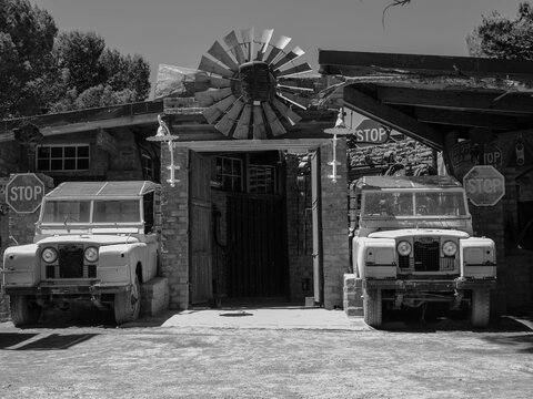Entry for the rustic Boorgat Bar in Sutherland. There arre two old landrovers build into the wall and a windmill above the door. Location Sutherland, South Africa, Western Cape