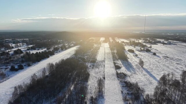 Rural winter landscape with agricultural fields and trees