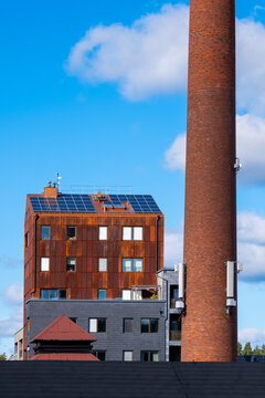 Brick rooftop and tall chimney define industrial architecture in Stockholm Sweden with urban skyline and modern city textures under clear daylight