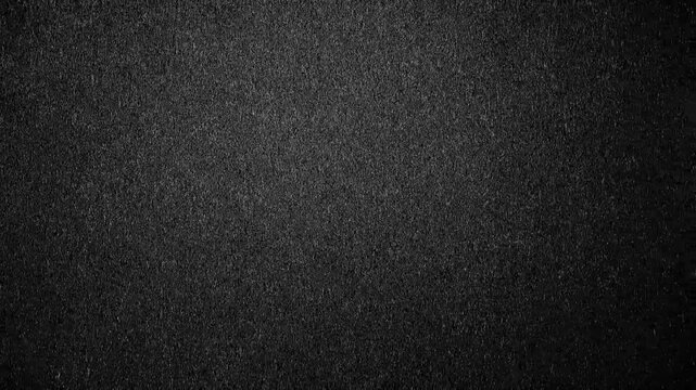 A dark, textured black leather surface features a macro skin pattern and rough material structure, creating a grey fabric backdrop design for a close-up textile wallpaper