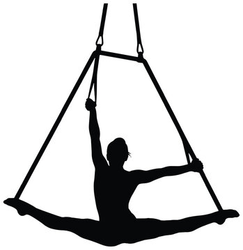 Silhouette of an aerial acrobat performing a full split on a suspended trapeze frame in a studio.