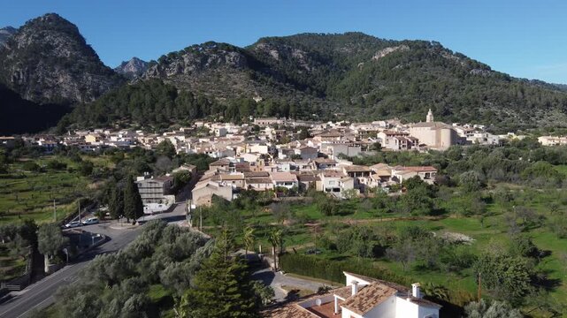 Aerial approach to the village of Caimari, with the Tramuntana mountain range in the background. Mallorca, Spain.