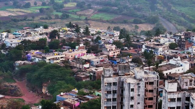 Farming lands with rural roads, residential buildings, trees, flying birds and apartments at bidar, karnataka, india. day time, push back shot, drone shot, 4k.