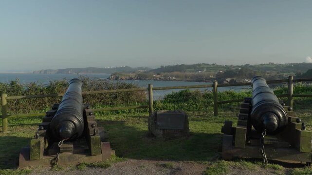 Old defensive cannons positioned on a coastal viewpoint overlooking the Atlantic Ocean in Cand&aacute;s, Asturias, Spain. Historic maritime defense site with scenic views of the coastline and sea.
