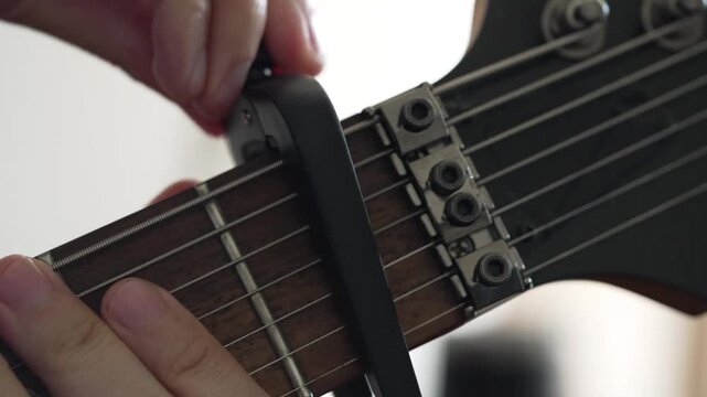 Capo Being Removed From Seven String Electric Guitar Neck